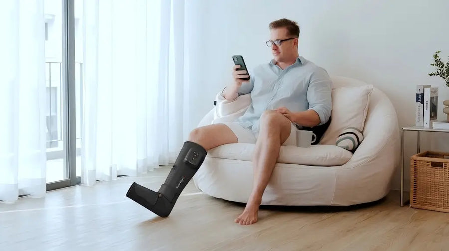 A man is using a remote-controlled foot air massager.