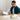Man working at a desk with a cordless hand massager on the table in front of him.