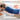 A woman lying down with a blue heating pad on her back for 15-20 minutes of moist heat relief.