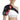 Woman wearing a Comfytemp shoulder brace with red light therapy glow and external controller.