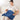 Smiling woman on a sofa using a blue Comfytemp electric heating pad on her lap.