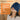 Woman wearing a blue weighted heat cap for migraine, sinus, and tension relief.