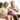 A senior couple smiling while simultaneously using a TENS unit on their legs, arms, and shoulder.