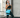 A woman in athletic wear wearing a blue gel ice pack wrap on her hip in a gym setting.