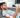 Man using TENS unit on arm while on phone