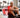 White rectangular red light therapy panel with stand illuminating a seated shirtless older man in a gym with treadmills in