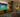 People watching a soccer match on a large TV with ambient backlighting in a cozy living room.