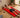Man lying on a full-body red LED light therapy mat in a living room.